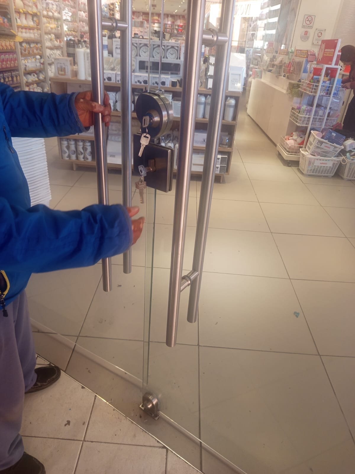 Servicio de Cerrajería 24/7 en la cerradura de una puerta de cristal de un local comercial